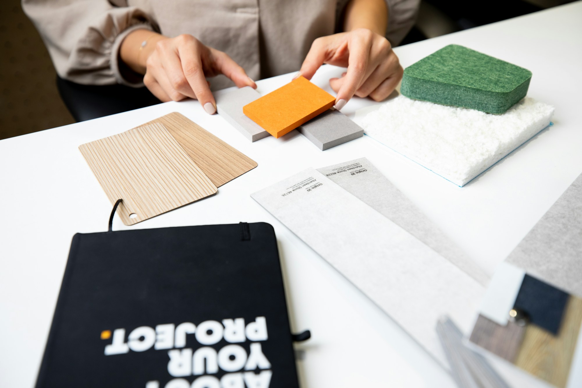 Designer comparing wood, textile and finish samples for an interior palette